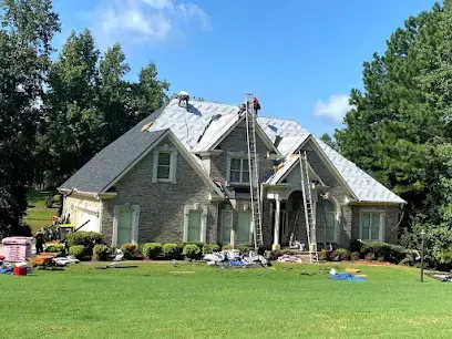 Roofers working on a two-story Gwinnett home after storm damage to the roof